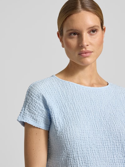 Frauenmodel trägt Relaxed Fit T-Shirt mit Strukturmuster von s.Oliver RED LABEL in Hellblau, Optik: Unifarben, Strukturmuster, Passform: Relaxed-Fit, Rundhals, Ärmelform: Kurzarm, Materialverarbeitung: Crinkle, Nahaufnahme Oberkörper.