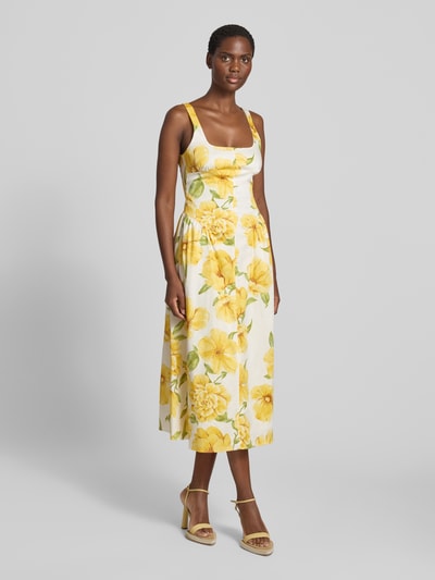 Frauenmodel trägt Midikleid im Allover-Look Modell 'ISLAND' von MANGO aus Baumwoll-Elasthan-Mix mit Karree-Ausschnitt, A-Linie, gelb-weiße florale Muster, strukturierte Oberfläche, Ganzkörperansicht von vorne. Rückenlänge bei Größe S: 100 cm, Brustweite: 39 cm.