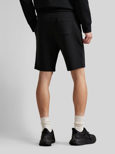 Männermodel trägt Regular Fit Sweatshorts aus Baumwoll-Mix von Polo Ralph Lauren, uni, Logo-Stitching, Ganzkörperansicht Rückansicht.