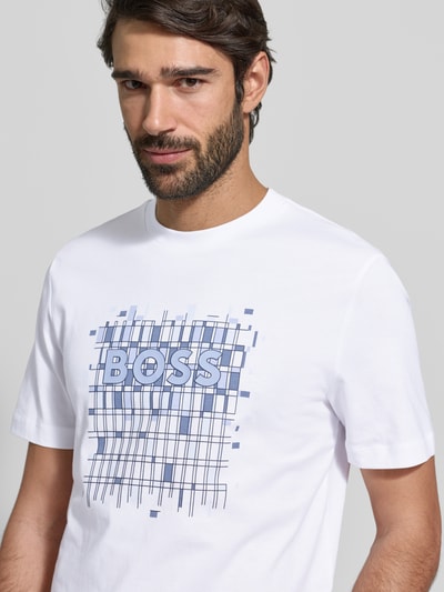 Männermodel draagt Regular Fit T-Shirt aus reiner Baumwolle Modell 'THOMPSON' van BOSS, wit, unifarben met labelprint, Nahaufnahme Oberkörper.