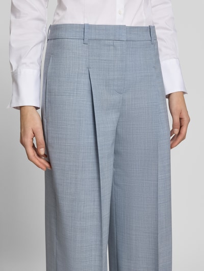 Frauenmodel trägt Wide Leg Bundfaltenhose aus reiner Schurwolle Modell 'TIANA4' von BOSS in hellgrauer Melange-Optik, Nahaufnahme Oberkörper.