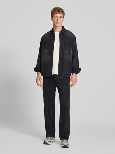 Männermodel trägt Regular Fit Jeanshemd aus reiner Baumwolle von Replay in Dunkelgrau, strukturierte Oberfläche, Ganzkörperansicht von vorne. Brusttaschen, Kentkragen, lange Ärmel, durchgehende Knopfleiste, entspannte Passform.