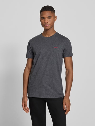 Männermodel trägt T-Shirt mit Label-Detail von Gant in Dunkelgrau, gerader Schnitt, Rundhalsausschnitt, reine Baumwolle, Ganzkörperansicht von vorne.