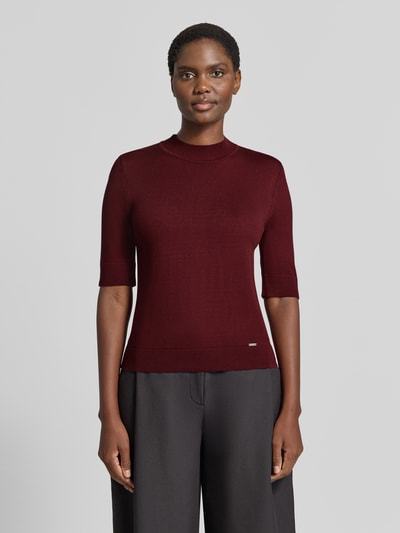 Vrouwenmodel draagt gebreid shirt uit Viscosemix met stretch, recht model, ronde hals, 1/2-mouwen, labeldetail van MORE, ruglengte maat 36: 55 cm, mouwlengte maat 36: 29 cm, Strickshirt aus Viskose-Mix met geribde ronde hals van MORE & MORE, voorkant full body shot.