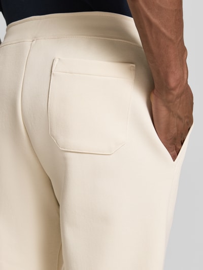 Männermodel trägt Regular Fit Sweathose aus Baumwoll-Mix von Polo Ralph Lauren in Beige mit glatter Textur, Nahaufnahme Rückansicht. Herren Sweathose.