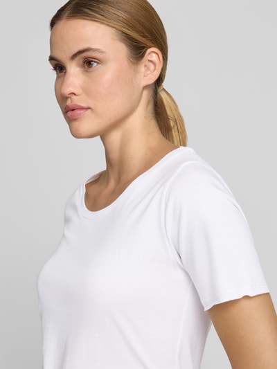 Frauenmodel trägt T-Shirt mit Rundhalsausschnitt von Juvia, Baumwoll-Mix, taillierter Schnitt, Saum im Used-Look, kurzärmelig, Nahaufnahme Oberkörper.