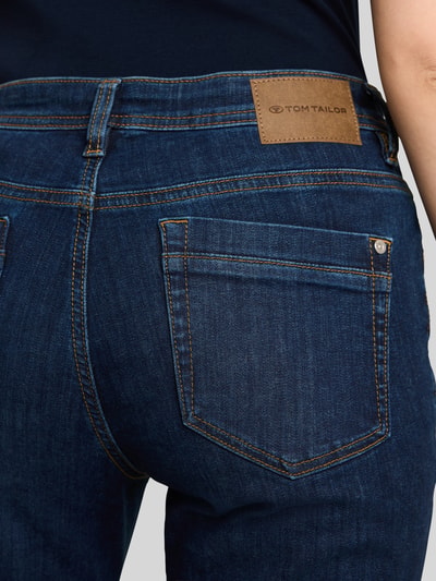 Vrouwenmodel draagt donkerblauwe tapered fit jeans uit mix van katoen en elastaan, Tapered Fit Jeans uit katoenmix model 'MAYA' van Tom Tailor, dames tapered fit jeans, detailopname rugaanzicht.