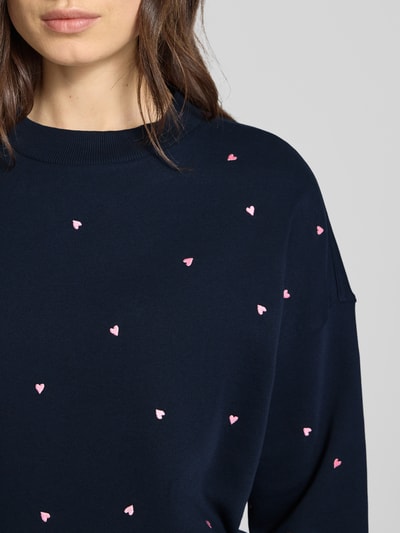 Frauenmodel trägt Regular Fit Sweatshirt aus reiner Baumwolle von Tom Tailor Denim, unifarben navy, Allover-Stickerei, Nahaufnahme Oberkörper.