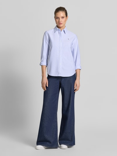 Frauenmodel trägt Relaxed Fit Hemdbluse aus reiner Baumwolle von Tommy Hilfiger, Optik: Unifarben, Oxford, Logo-Detail, Ganzkörperansicht von vorne.