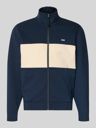 Produktfoto, Sweatjacke mit Label-Patch Modell 'KOSTER' von Helly Hansen, bawełniany miks z dodatkiem stretchu, prosty krój, kolor granatowy z beżowym panelem, stójka, zamek błyskawiczny, boczne kieszenie, długość tyłu w rozmiarze M: 67 cm, długość rękawa w rozmiarze M: 66 cm