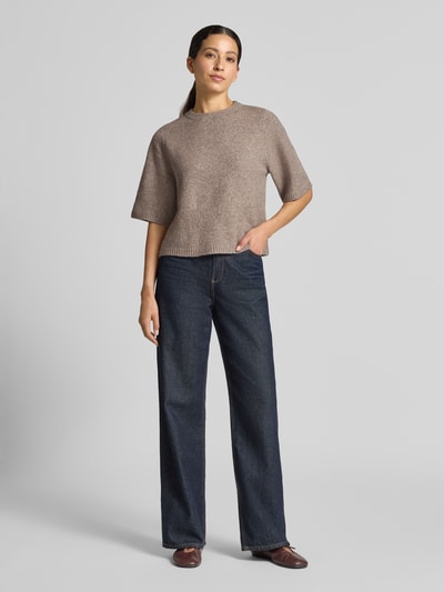 Modelka nosi sweter z dodatkiem wełny model 'BOOM' od VERO MODA w kolorze beżowym, krój oversized. Ganzkörperansicht von vorne.