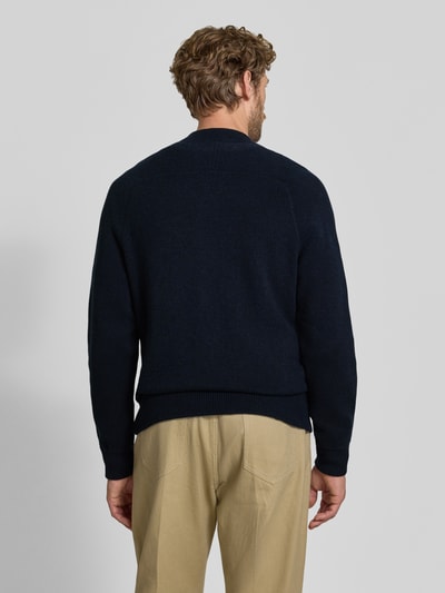 Männermodel trägt Regular Fit Strickjacke aus Baumwoll-Mix mit Kaschmir-Anteil von FTC Cashmere in Dunkelblau, College-Stil, Ganzkörperansicht Rückansicht.