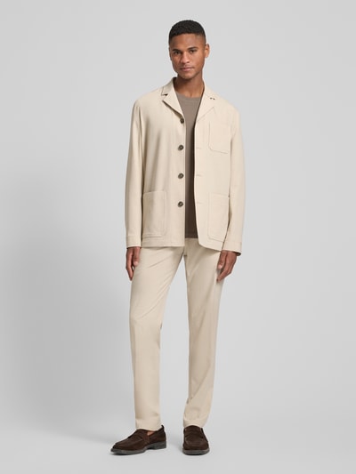 Männermodel trägt Relaxed Fit Hemdjacke mit Viskose-Anteil Modell 'Bill' von DIGEL, Beige mit aufgesetzten Taschen, Ganzkörperansicht von vorne.