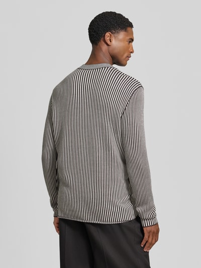 Männermodel draagt Regular Fit Strickpullover aus Schurwolle-Mix mit Streifenmuster van Armani Exchange, Heren, streepmotief, regular fit, ruglengte maat M 70 cm, mouwlengte maat M 69 cm, elastische boordjes, zwart-witte tinten, rechte lijnen, zachte textuur, Ganzkörperansicht Rückansicht.