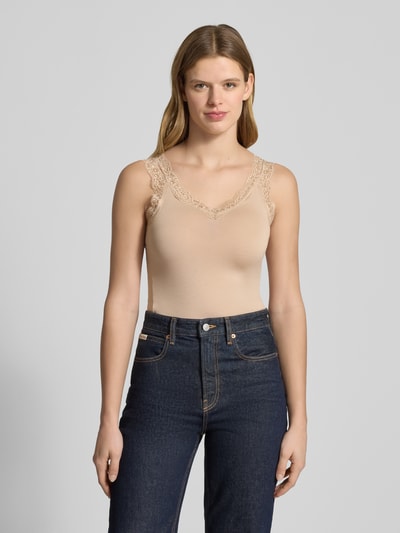 Frauenmodel trägt Slim Fit Tank Top aus Viskose-Mix Modell 'BARBERA LACE' von Pieces, cremefarben, Spitze am V-Ausschnitt, Nahaufnahme Oberkörper.