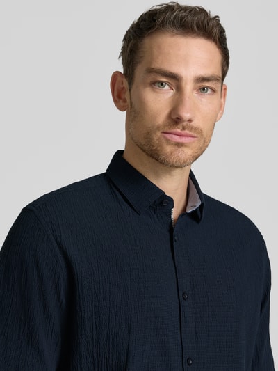 Männermodel trägt Comfort Fit Freizeithemd aus Lyocell-Baumwoll-Mix von Tom Tailor, Optik: Unifarben, Struktur, Nahaufnahme Oberkörper.