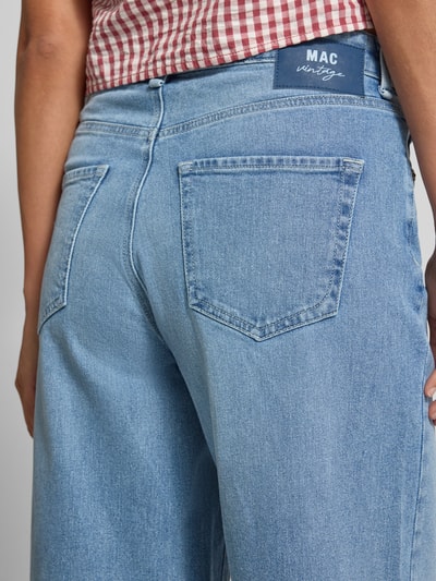 Frauenmodel trägt Jeans mit Fransen Modell 'Nevada' von MAC, hellblaue Farbe, Baumwoll-Mix mit Stretch-Anteil, Nahaufnahme Rückansicht. Bundweite 40 cm, Innenbeinlänge 79 cm, Wide Leg.