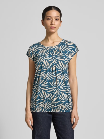 Frauenmodel trägt Regular Fit Bluse aus Viskose-Mix Modell 'Minou' von ZABAIONE mit Floraler-Allover-Print, Kurzärmelig, Rundhalsausschnitt, Elastischer Bund, Rückenlänge 62 cm, Ganzkörperansicht von vorne.