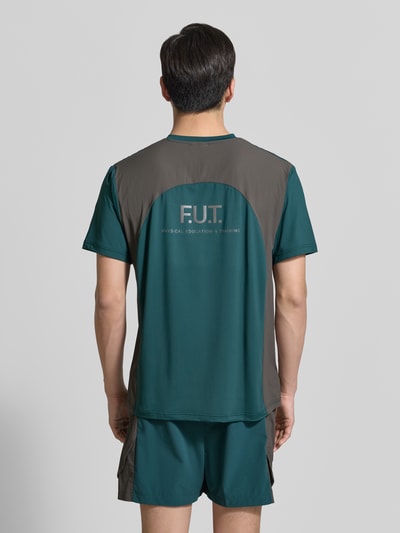 Männermodel trägt Herren T-Shirt mit Logo Modell 'DIVISION' von HALO in Grün und Braun, Material-Mix mit Stretch-Anteil, Regular-Fit, Rückenlänge bei Größe M 69 cm, Rundhalsausschnitt, Ganzkörperansicht Rückansicht.