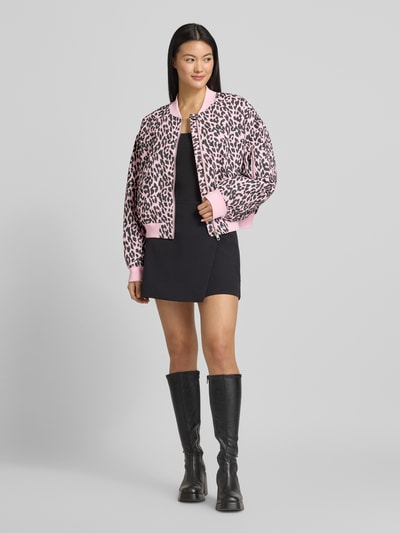 Modelka kobieca nosi Bomberjacke mit Eingrifftaschen Modell 'Liw' od LOLLYS LAUNDRY w różowo-czarną panterkę, luźny krój, całkowity widok z przodu.