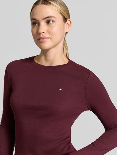 Frauenmodel trägt Slim Fit Langarmshirt aus reiner Baumwolle von Tommy Hilfiger in dunkelrot, glatte Textur, Nahaufnahme Oberkörper, Damen Langarmshirt von Tommy Hilfiger