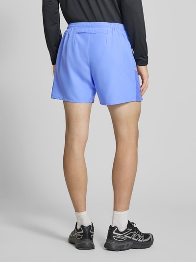Männermodel trägt Shorts mit seitlichen Eingrifftaschen und Logo-Print von NIKE TRAINING in Hellblau, lockere Passform, Ganzkörperansicht Rückansicht.