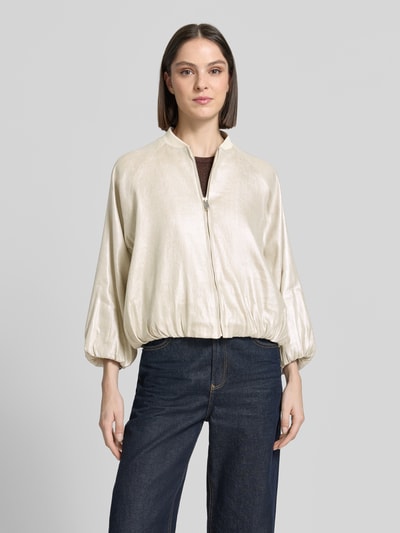 Frauenmodel trägt Schimmernde Jacke mit Reißverschluss Modell 'Noema' von Someday, Regular-Fit, Stehkragen, helle schimmernde Optik, Rückenlänge 48 cm, Schulterbreite 43 cm, Brustweite 64 cm, Ärmellänge 46 cm, Ganzkörperansicht von vorne.