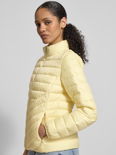Vrouwenmodel draagt Slim Fit Steppjacke met Stehkragen van s.Oliver RED LABEL in effen lichtgeel met rits en zijzakken, ganzebovenaanzicht van voren.