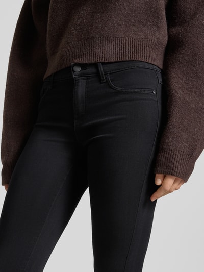 Kobiece modelka nosi Coloured Skinny Fit Jeans od ONLY, czarne, 5-kieszeniowe, z mieszanki wiskozy, skinny, zapięcie na guzik i zamek, z przodu, zbliżenie na górną część ciała.