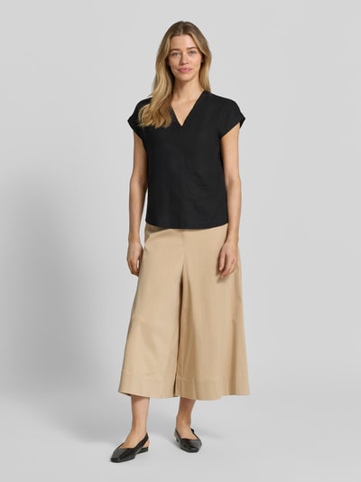 Frauenmodel trägt Blusenshirt aus Leinen-Viskose-Mix Modell 'INA' von Soyaconcept in Schwarz, gerader Schnitt, V-Ausschnitt, Kappärmel, Ganzkörperansicht von vorne. Damen Blusenshirt mit Rückenlänge 61 cm und Ärmellänge 20 cm bei Größe S.