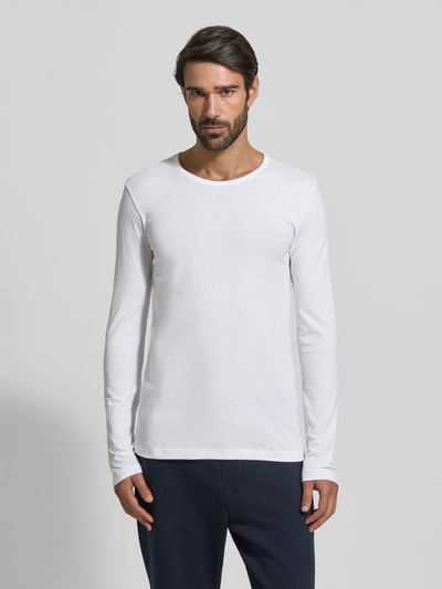 Männermodel trägt Longsleeve mit geripptem Rundhalsausschnitt von Schiesser, Baumwoll-Elasthan-Mix, Slim Fit, weiß, Ganzkörperansicht von vorne.