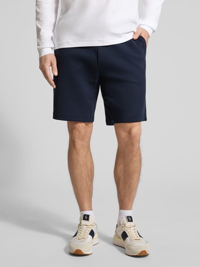 Männermodel trägt Regular Fit Sweatshorts aus Baumwoll-Mix von Polo Ralph Lauren in Dunkelblau, unifarben, mit Logo-Stitching, Ganzkörperansicht von vorne.