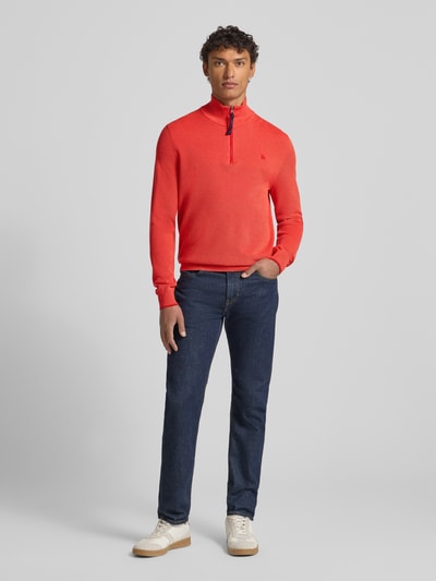 Männermodel trägt Strickpullover mit Troyer-Kragen von Lerros in leuchtendem Rot aus reiner Baumwolle, Regular-Fit, gerippte Abschlüsse, kurzer Reißverschluss, Label-Stitching, Rückenlänge 71 cm, Ärmellänge 78 cm, Ganzkörperansicht von vorne.