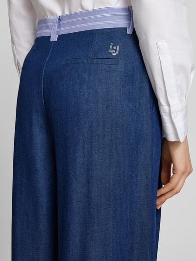 Frauenmodel trägt Wide-Leg-Pants mit Eingrifftaschen von Liu Jo White aus Lyocell in Blau, Gesäßtaschen, Detailaufnahme Rückansicht.