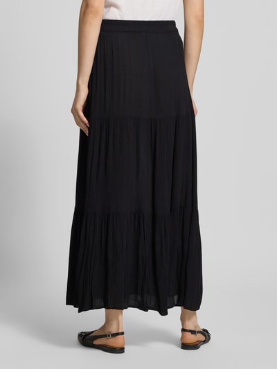 Frauenmodel trägt Ausgestellter Maxi-Rock aus reiner Viskose Modell 'MIKKA' von Only in Schwarz, Crinkle-Optik, Ganzkörperansicht Rückansicht.