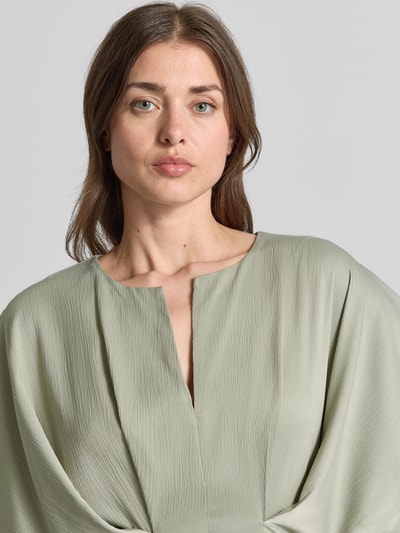 Vrouwenmodel draagt Midikleid met V-hals model 'VIANNA' van Copenhagen Muse in lichtgroene kleur met draperingen, getailleerde fit, detailopname bovenlichaam