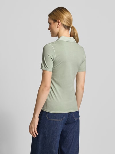 Vrouwenmodel draagt Regular Fit Poloshirt aus reiner Baumwolle van Marc O'Polo, look: effen, regular fit pasvorm, logoprint, polokraag, korte knoopsluiting, korte mouw, borstzak, jersey materiaalverwerking, puur katoen, ganzlichaamsaanzicht achteraan.