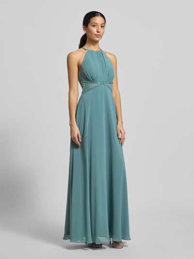 Modelka kobieca ma na sobie Regular Fit Abendkleid mit Ziersteinbesatz od Jake*s Cocktail, turkusowy, ozdobione kamieniami, krój regular fit, dopasowana talia, półprzezroczyste partie, dekolt typu halter, marszczenia, nieprzezroczysta podszewka, długość pleców w rozmiarze 36: 156 cm, szerokość w rozmiarze 36: 38 cm, widok całej sylwetki z przodu.