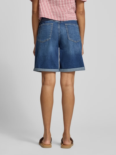 Männermodel trägt Regular Fit Jeansshorts aus bawełnianego miksu Modell 'SURI' von s.Oliver RED LABEL, wygląd denim, detale nity, label patch, szlufki, 5 kieszeni, zapięcie na guzik i kryty zamek, mankiet na nogawce; widok całej sylwetki z tyłu.
