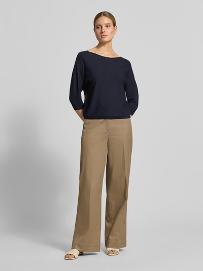 Modelka nosi Relaxed Fit Pullover aus Viskose-Mix in Strick-Optik von comma, kolor granatowy, miękka faktura, U-boot dekolt, rękaw 3/4, elastyczne wykończenia, długość tyłu 47 cm, długość rękawa 45 cm, cały widok z przodu.