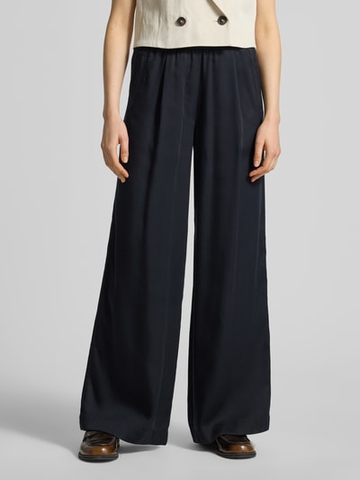 Frauenmodel trägt Wide Leg Stoffhose mit elastischem Bund von Lanius aus reinem Lyocell in Dunkelblau, mit Eingrifftaschen, Ganzkörperansicht von vorne.