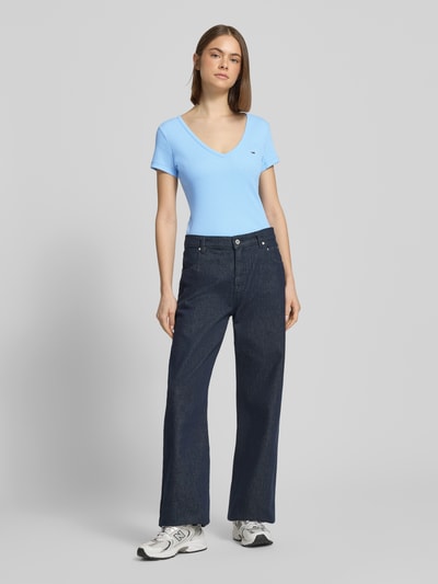 Vrouwenmodel draagt Slim Fit T-shirt uit katoenmix van Tommy Jeans in look: effen kleuren, gestikt logo, ronde hals, korte mouw, jersey; Ganzkörperansicht van voren.