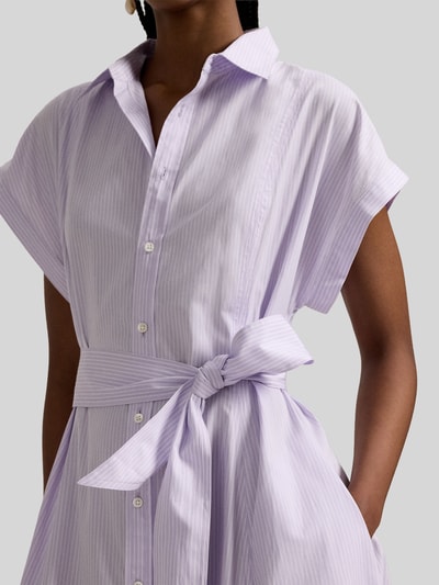 Frauenmodel trägt Tailliertes Hemdblusenkleid aus reiner Baumwolle von Polo Ralph Lauren in einfarbigem Flieder, mit Knopfleiste, Logo-Stitching und Taillengürtel, seitliche Eingrifftaschen, kurzarm, glatte Baumwollstruktur, Nahaufnahme Oberkörper.