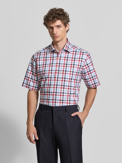 Männermodel trägt Comfort Fit Business-Hemd mit Kentkragen von ETERNA, kariertes Muster in Rot, Blau, Weiß, Reine Baumwolle, Knopfleiste, Brusttasche, abgerundeter Saum, Rückenlänge 79 cm, Schulterbreite 45 cm, Ärmellänge 30 cm, Nahaufnahme Oberkörper.