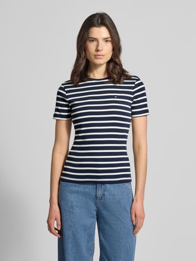 Frauenmodel trägt Slim Fit T-Shirt aus reiner Baumwolle von Tommy Hilfiger, Optik: Unifarben, Logo-Stitching, Rundhals, Kurzarm, Jersey, Ganzkörperansicht von vorne.