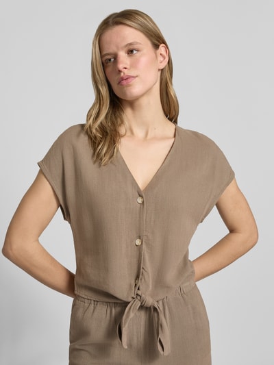 Frauenmodel trägt Regular Fit Blusentop aus Viskose-Leinen-Mix Modell 'SIESTA' von Only in Melange-Optik mit V-Ausschnitt, Knotendetail, einreihiger Knopfleiste und Flammgarn-Textur, Nahaufnahme Oberkörper.