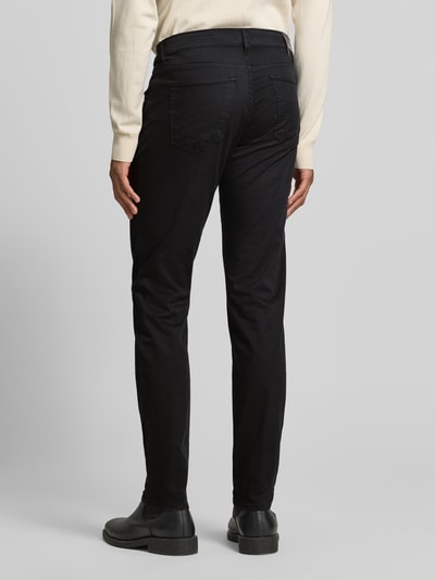 Männermodel trägt Hose mit Eingrifftaschen Modell 'Chuck' von BRAX, schwarzer Baumwoll-Lyocell-Mix, Slim-Fit, Ganzkörperansicht Rückansicht.