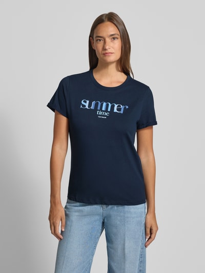 Frauenmodel trägt Regular Fit T-Shirt aus reiner Baumwolle von Tom Tailor in Optik: Unifarben mit Statement-Print-Applikation, Rundhals, Kurzarm, Materialverarbeitung: Jersey, Ganzkörperansicht von vorne.