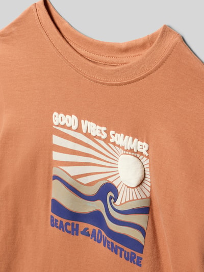 Produktfoto, T-Shirt mit Motiv-Print von Blue Seven, Kinder T-Shirt aus Reine Baumwolle, Regular-Fit, Rundhalsausschnitt, Rückenlänge 39 cm Größe 116, sandfarben mit blauem und weißem Print, wellige Formen, glatte Baumwoll-Textur.