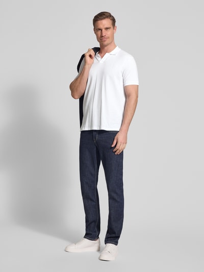 Männermodel trägt Slim Fit Poloshirt aus Baumwoll-Mix von Polo Ralph Lauren in Optik: Unifarben mit Logo-Detail, Ganzkörperansicht von vorne.